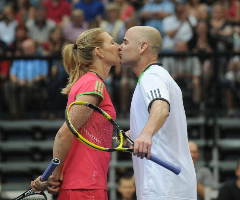 Steffi Graf and husband Andre Agassi kiss on the tennis court